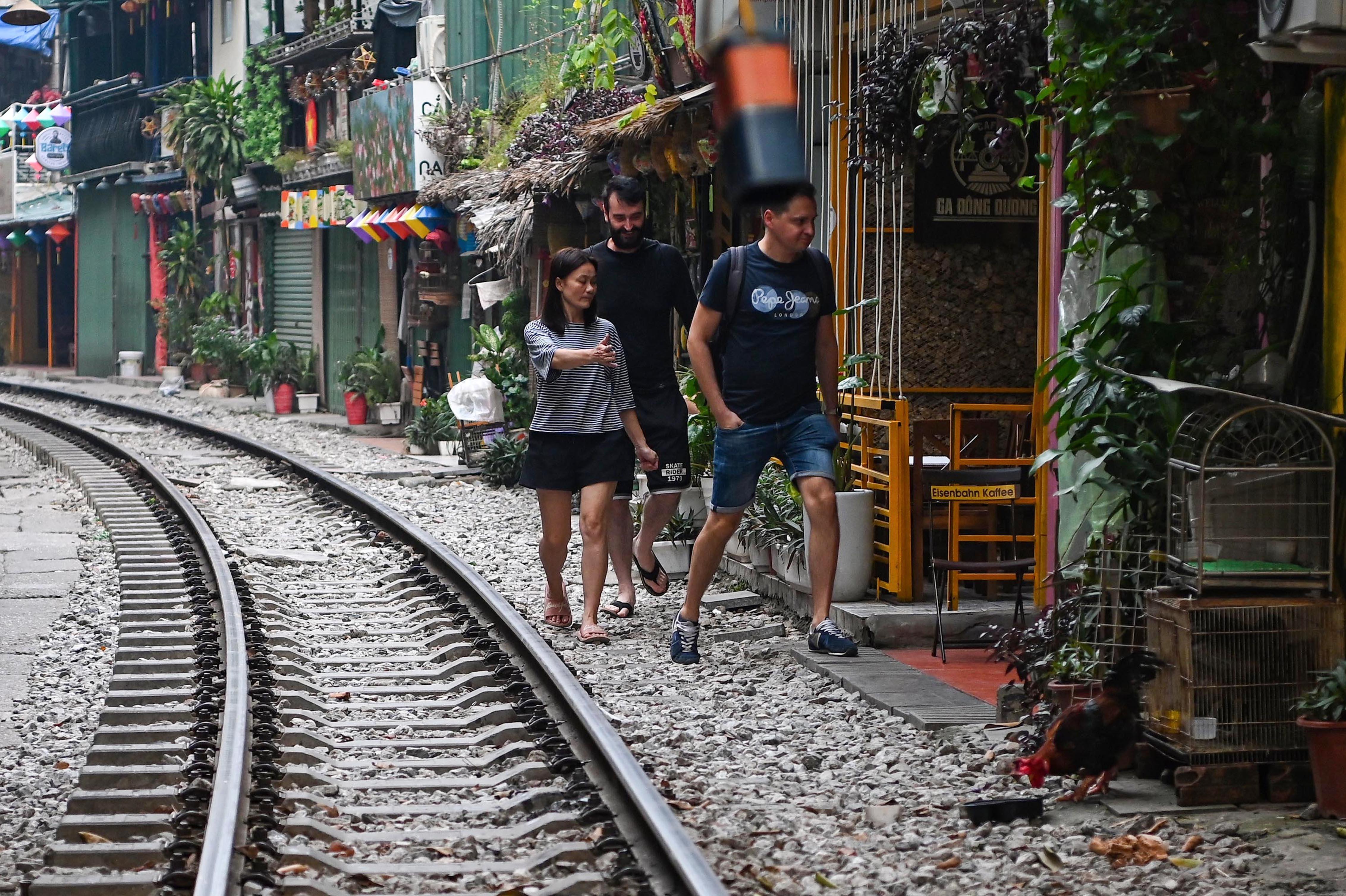 Dù đã có hàng rào và biển cảnh báo bằng tiếng Anh, khách nước ngoài vẫn tìm cách tiếp cận phố cà phê đường tàu theo chỉ dẫn của nhân viên quán cà phê. Ảnh: Hồng Quang.