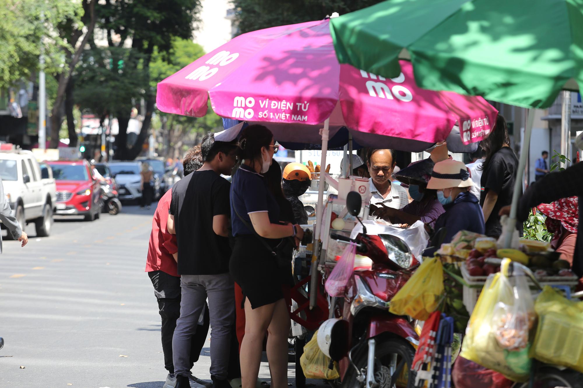 TP.HCM nắng nóng rát mặt sau Tết, người dân ngủ gầm cầu, tưới nước giải nhiệt  - Ảnh 7.