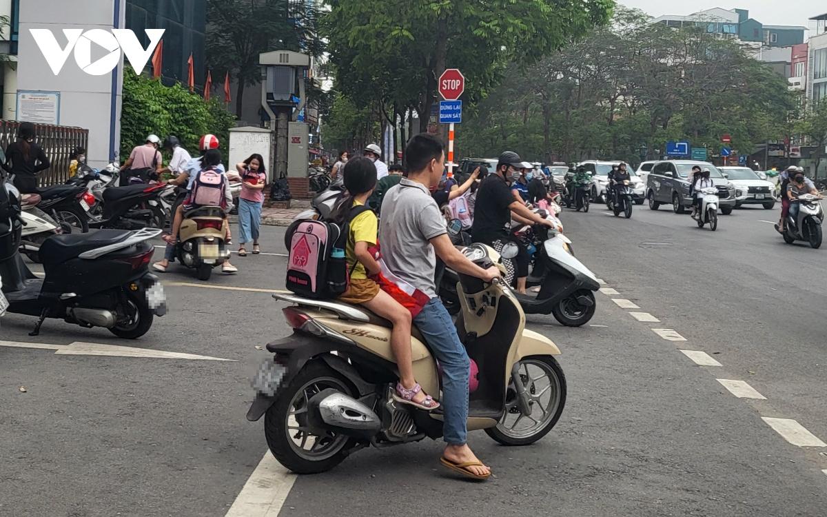 Nhiều phụ huynh Hà Nội không đội mũ bảo hiểm, lượn lách trong giờ tan tầm đi đón con - Ảnh 3.