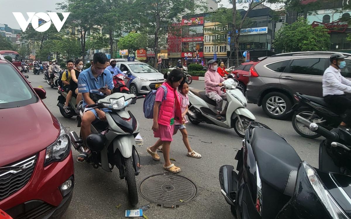 Nhiều phụ huynh Hà Nội không đội mũ bảo hiểm, lượn lách trong giờ tan tầm đi đón con - Ảnh 2.