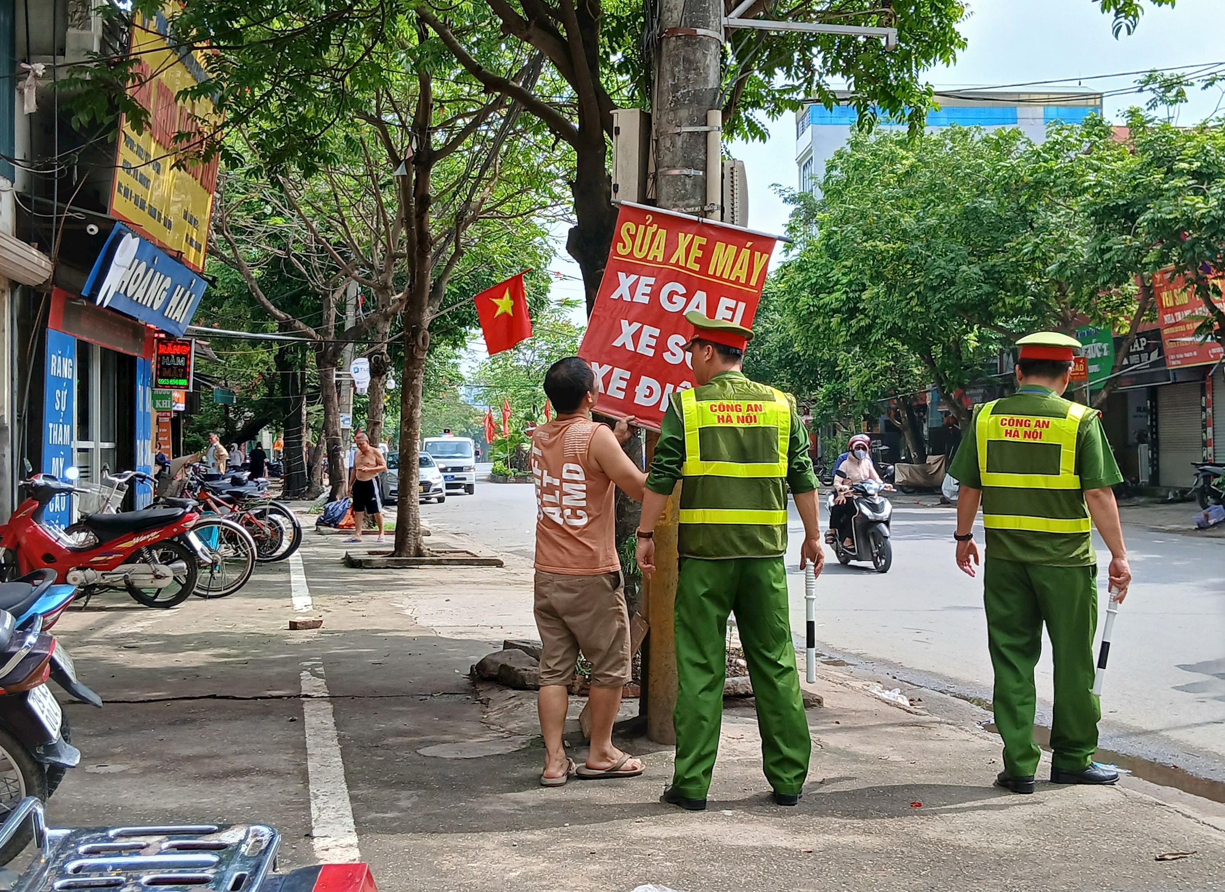 Xử lý, bóc gỡ biển báo treo không đúng nơi quy định. Ảnh: oàng Quyết