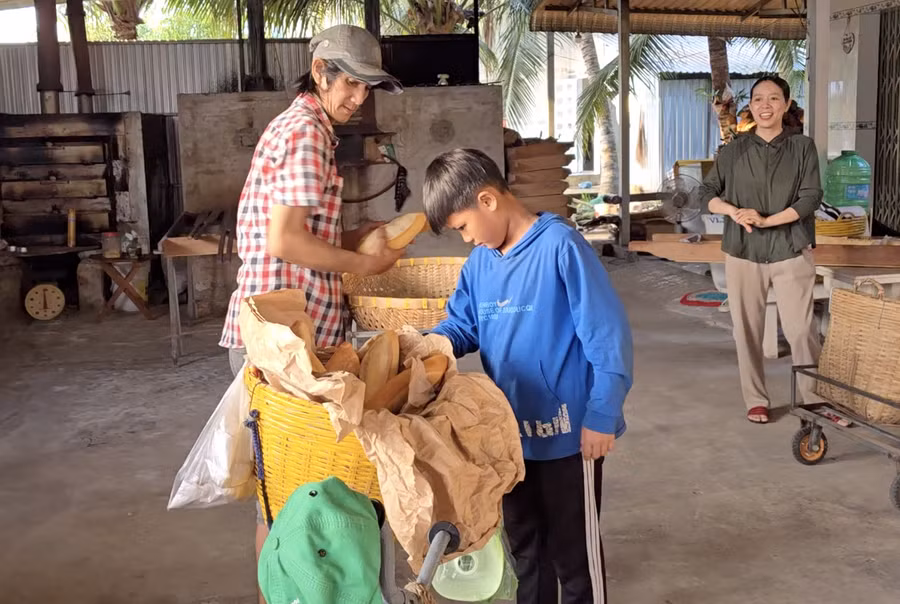 Vợ chồng anh Nguyễn Văn Hòa và chị Đoàn Thị Hồng Nhung - chủ lò bánh mì thương Bằng như con ruột, tạo mọi điều kiện cho cậu bé tích cóp từng đồng để mua sách vở, đồng phục. anh-man-hinh-2026-07-20-luc-200437.png